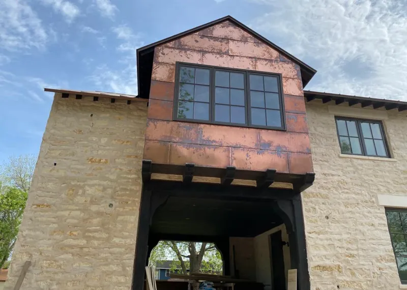 Copper metal panel facade on a stone building for Skylight Installation in Butler